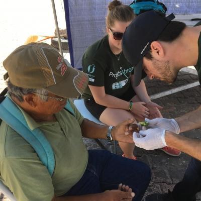 Un estudiante en Belice mide los niveles de glucosa durante sus prácticas de Salud Pública en Belice. En nuestras prácticas de salud pública ayudarás a doctores a brindar tratamientos básicos.